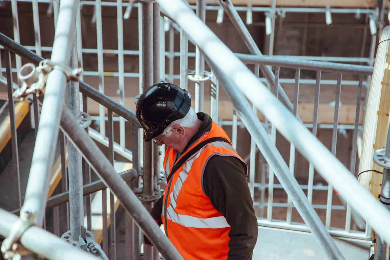 Kevin E. Cahill Publishes Academic Article on Bridge Employment Man in safety vest and hard hat inspecting scaffolding