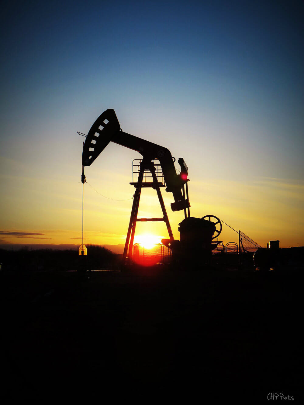 View of an oil derrick with sunset behind